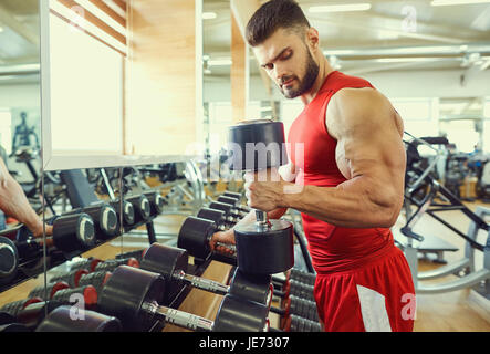 Bodybuilder athlete with dumbbells in the gym Stock Photo