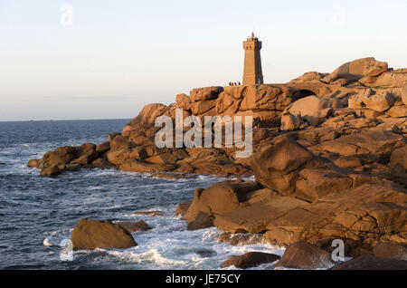 Europe, France, Brittany, Cote de granite rose, Ploumanach, granite rock in coastal scenery, in the background a lighthouse, Stock Photo