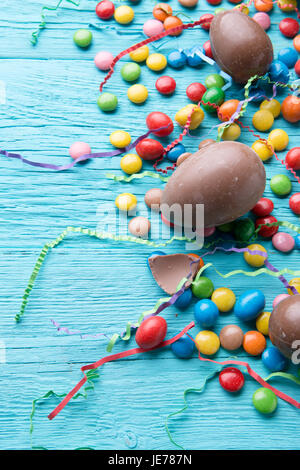 Photo of eggs, chocolates, ribbons on blue wooden table Stock Photo