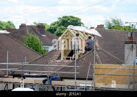 Builders constructing a loft extension on a suburban bungalow England UK Stock Photo