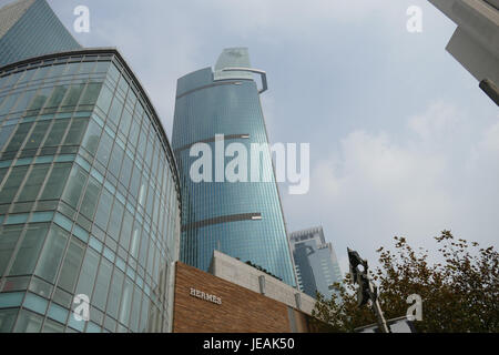 A photo taken on November 17, 2014, showcasing buildings along Nanjing West Road in Shanghai, China. The urban landscape highlights the modern architecture and commercial activity in the city center. Stock Photo