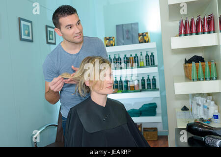 smiling man hairdresser talking to female client in beauty salon Stock Photo
