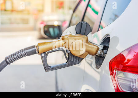 White car at gas station being filled with fuel on thailand Stock Photo