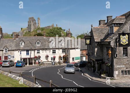 The Greyhound pub in Corfe Castle Dorset England UK overlooked by the castle ruins. Stock Photo