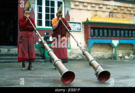 India, West Bengal, Ghum, Two Yellow Sect Buddhist monks at Choling monastery near Darjeeling playing long horns. Stock Photo