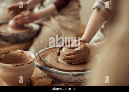 Close up of child hands working on pottery wheel at workshop Stock Photo