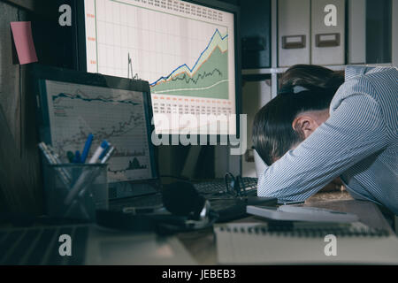 young lady accounting feeling tired at night and sleeping on the workplace table. asia businesswoman work overtime all night. Stock Photo