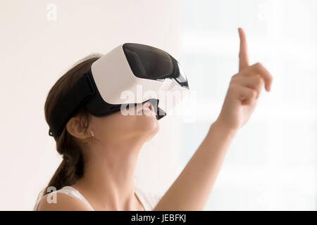 Woman using VR glasses for interactive videos Stock Photo