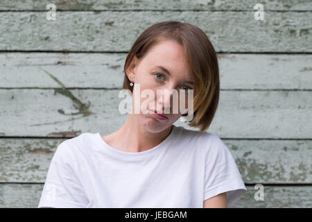 portrait of beautiful young angry woman in white t-shirt Stock Photo