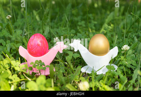 Golden and pink Easter eggs in egg cups Stock Photo