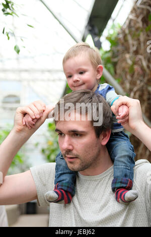 baby boy sitting on dad's shoulders Stock Photo