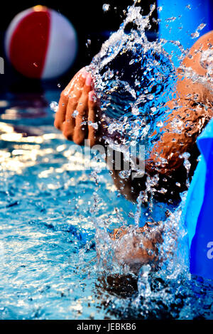 closeup of a young caucasian man having fun in an air mattress, in a portable swimming pool placed in the backyard Stock Photo