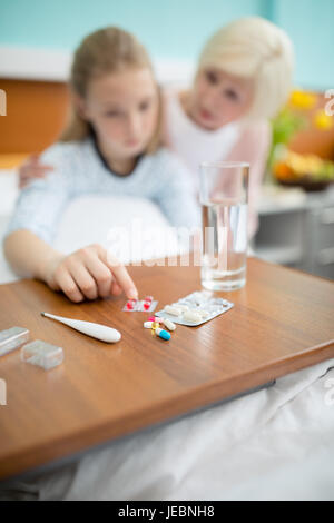 Close-up view of grandmother and granddaughter with medical capsules in hospital Stock Photo
