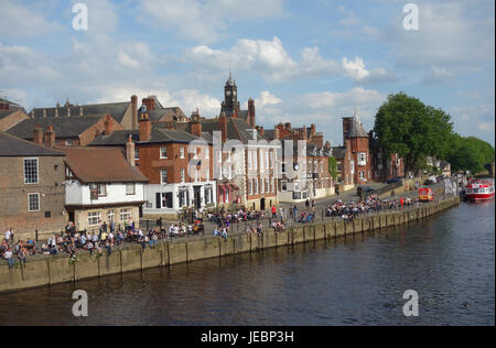 People sitting outside pubs on sunny day by River Ouse, York, North Yorkshire Stock Photo