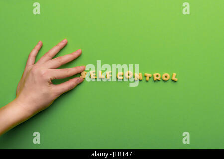 self controt concept,  person making words of cookies isolated on green. healthy lifestyle and healthy living concept Stock Photo