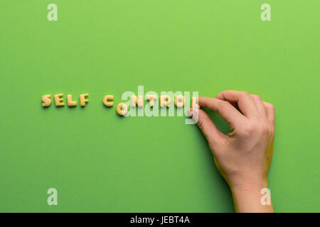 self controt concept,  person making words of cookies isolated on green. healthy lifestyle and healthy living concept Stock Photo