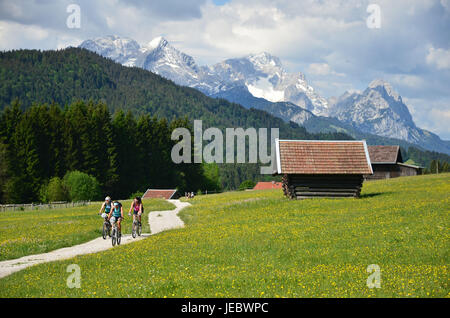 Germany, Bavaria, Werdenfels, Geroldsee, meadow way, spring, mountain biker, Zugspitze group, Stock Photo