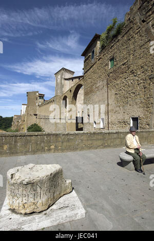 Italy, Tuscany, Maremma, Pitigliano, old man sits before the city wall, Stock Photo
