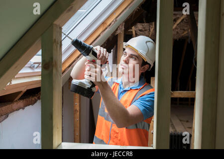 Construction Worker Using Drill To Install Replacement Window Stock Photo