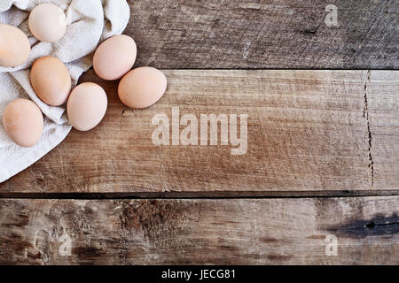 Farm fresh organic brown chicken eggs from free range chickens over a rustic wooden background. Stock Photo
