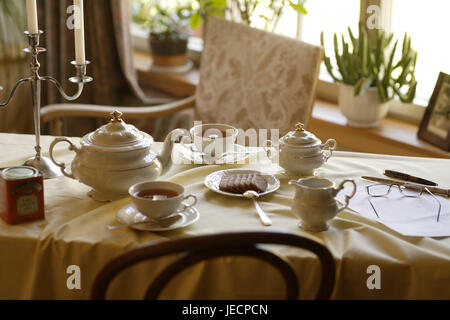 Coffee table, covered, porcelain, elegantly, table, table caps, white, dishes, china, tea service, cups, teapot, tea drinking, Teatime, tea, sugar bowl, lacteal pot, biscuits, reading glasses, ballpoint pens, candlesticks, chair, window, nobody, Stock Photo