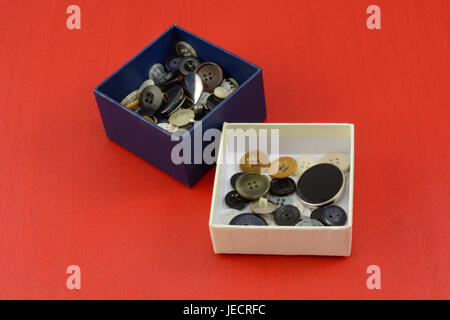 Collection of buttons in white and blue boxes on red wooden background Stock Photo