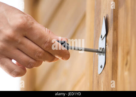closeup of hand unlocking front door of house Stock Photo