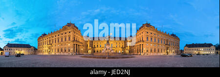 Panoramic view of illuminated Wurzburg Residence palace from Residenzplatz square in the evening, Wurzburg, Germany Stock Photo