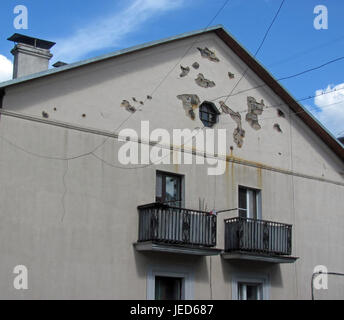 Peeling off the facade of the house, the plaster has fallen off Stock Photo
