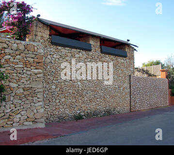 Wall of a garage, houses made of decorative natural stone Stock Photo