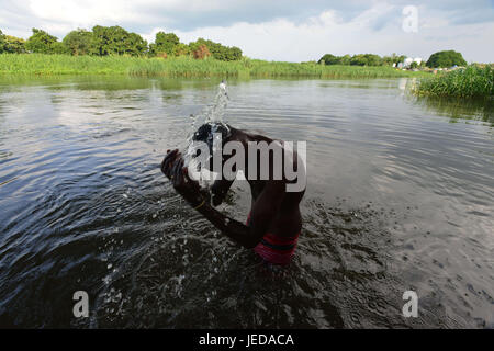 Juba, Central Equatorial, South Sudan. 23rd June, 2017. A young Muslim man bathes in the Nile River to cope with the heat and the rigor of fasting as the Muslim holy month of Ramadan comes to an end in Juba, South Sudan, the world's newest nation, where civilians have been devastated by a civil war that has left roughly two-thirds of the nation facing famine. Credit: Miguel Juarez Lugo/ZUMA Wire/Alamy Live News Stock Photo