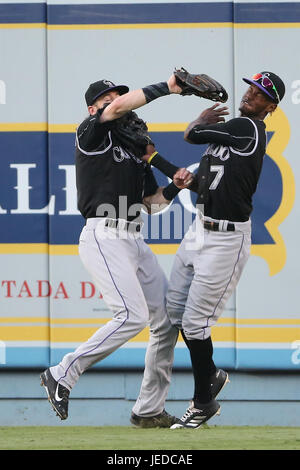 Colorado Rockies' Charlie Blackmon, left, shows to trainer Scott Gehret  where a foul ball hit his batting helmet as he stood in the on-deck circle,  during the third inning of the team's