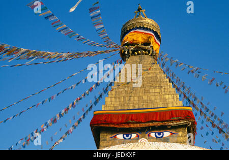 Nepal, Kathmandu Valley, Bodhnath, Detail of Bodhnath stupa hung with prayer flags and showing the painted eyes of Buddha. Stock Photo