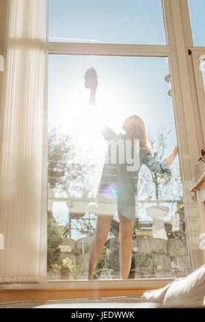 Woman cleaning the window in sunshine Stock Photo