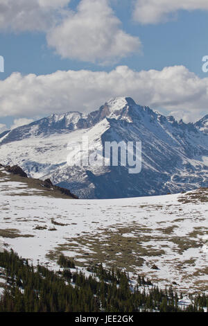 The Summit of Longs Peak as seen from Trail Ridge Road with white puffy clouds in the blue sky Stock Photo