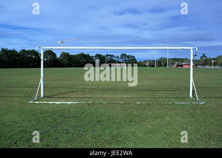 Football playground in Australia. Soccer playground with goal posts, flood lights, trees and a crane in the far distance. Stock Photo