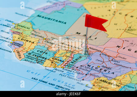 Photo of Benin marked by red flag in holder. Country on African continent. Stock Photo