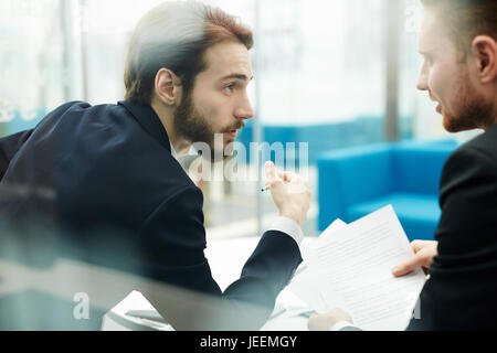 Two young traders discussing business papers Stock Photo