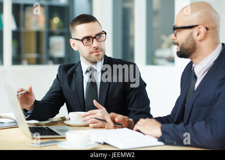 Traders discussing new project in laptop Stock Photo