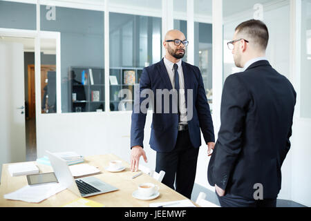 Two elegant employees having talk in office Stock Photo
