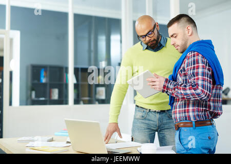 Two creative designers having discussion of ideas for project at start-up meeting Stock Photo