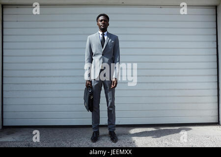 African-american businessman standing by garage door Stock Photo