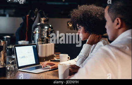 Business people working late on laptop. Business partners using laptop computer at startup office. Stock Photo