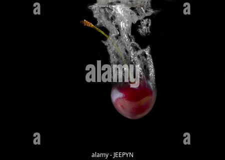 Cherries, splash, splashes, bubbles on a black background. Stock Photo