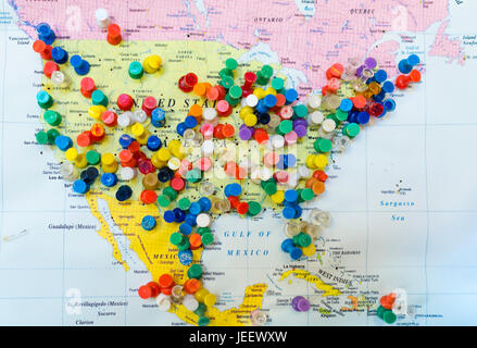 Many colourful pins in a wall map of America. The map is hanging on the wall of a US tourist destination where visiting tourists are asked to mark the Stock Photo