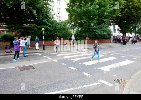 Tourists Crossing The Zebra Crossing Made Famous By The Beatles Outside Abbey Road Studios, London, UK Stock Photo