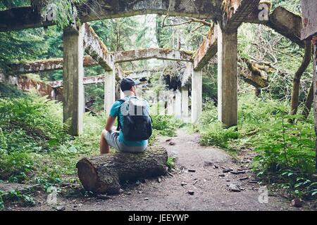 Young explorer inside of the abandoned old ruined factory in the middle of the forest. Ore mountains, Czech Republic Stock Photo