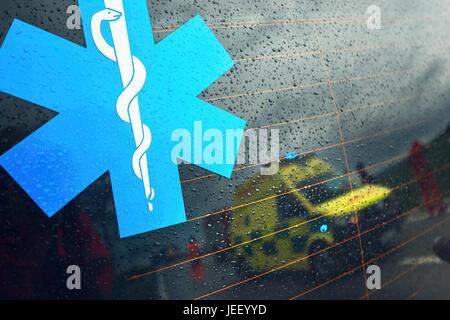 Reflection of the ambulance car. Teams of the Emergency medical service are responding to an traffic accident in bad weather. Stock Photo