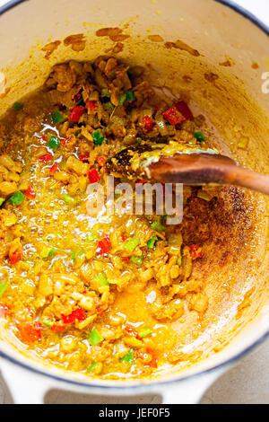 Making curry paste out of fried onions, grated ginger, chilli peppers and spices Stock Photo