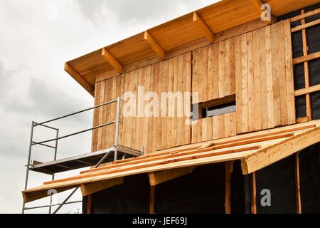 Ecological construction. Lining the house of larch boards. Heat insulation. Construction works Stock Photo